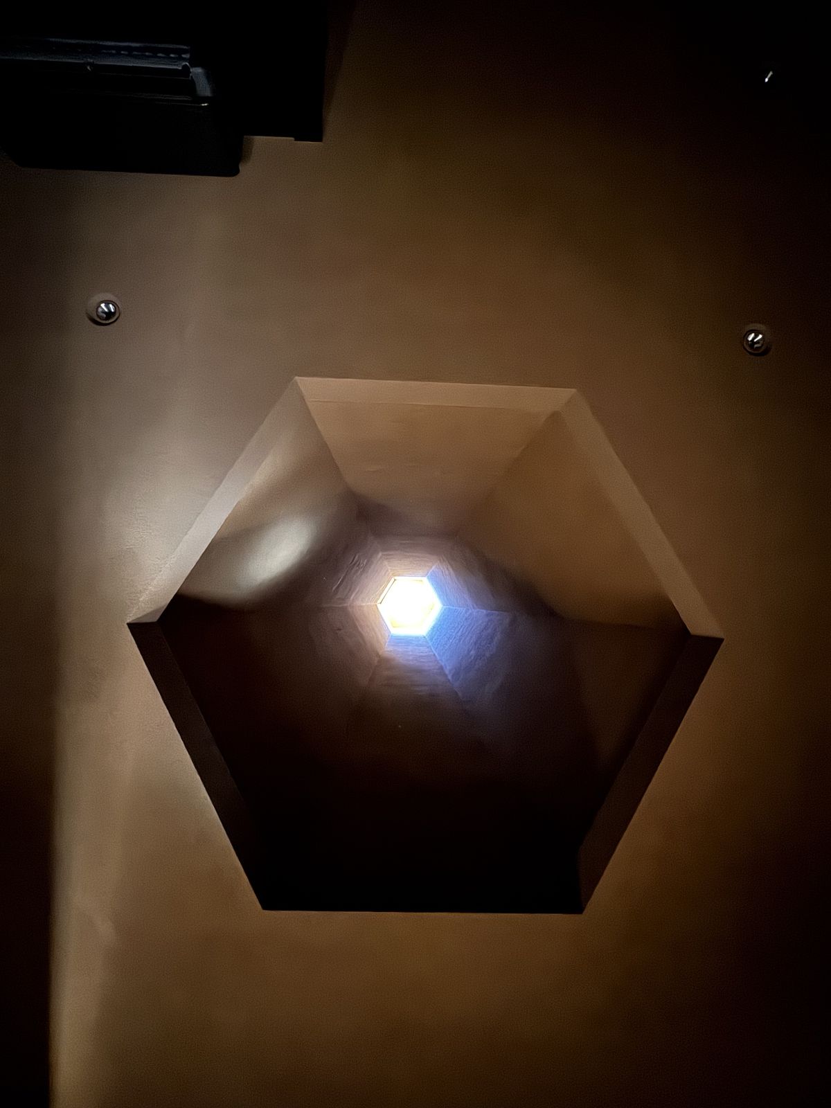 夜裡房間天花板上的風煙囪開口，透入一點微光
